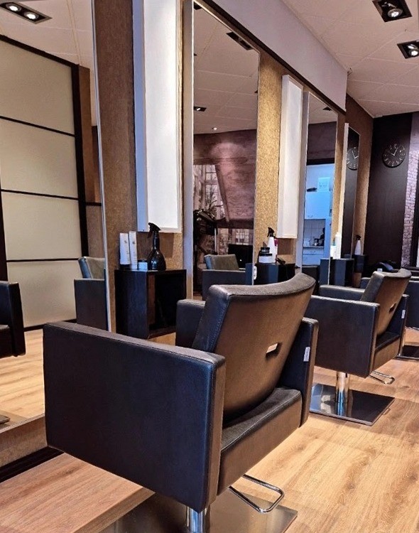 Zwarte kappersstoelen voor de spiegels in de kapsalon